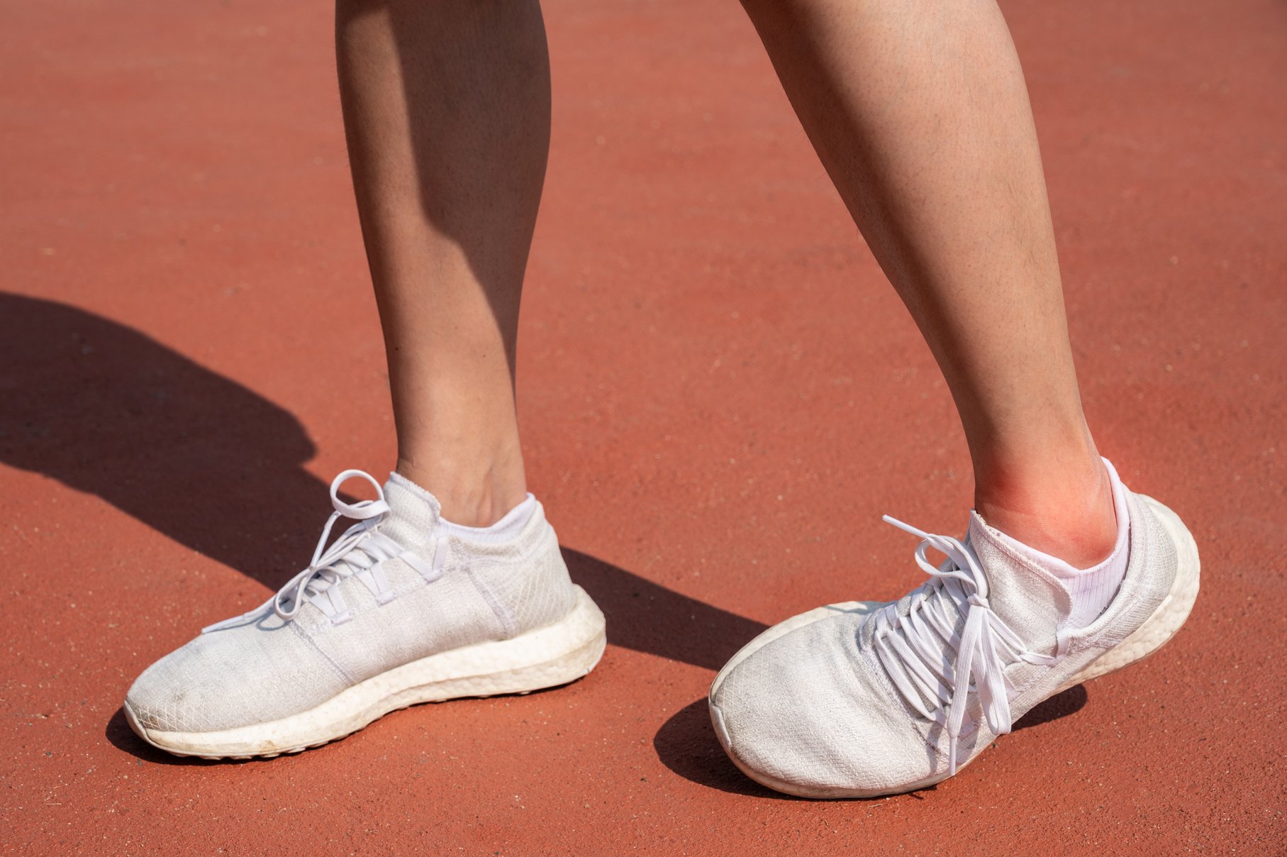 Close up of female runner legs having an ankle sprain problem after workout.